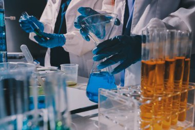 Bilimadamı laboratuarda tıbbi örnekleri mikro plakaya yerleştiriyor.