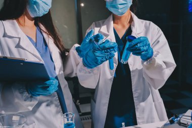 Bilimadamı laboratuarda tıbbi örnekleri mikro plakaya yerleştiriyor.