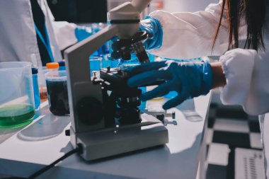 Bilimadamı laboratuarda tıbbi örnekleri mikro plakaya yerleştiriyor.