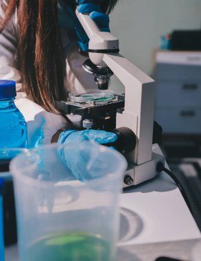 Bilimadamı laboratuarda tıbbi örnekleri mikro plakaya yerleştiriyor.