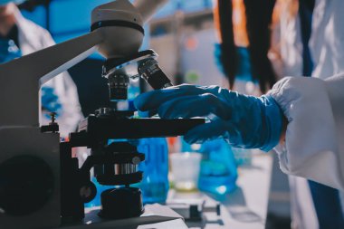 Bilimadamı laboratuarda tıbbi örnekleri mikro plakaya yerleştiriyor.