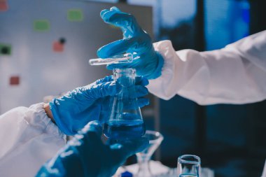 Bilimadamı laboratuarda tıbbi örnekleri mikro plakaya yerleştiriyor.