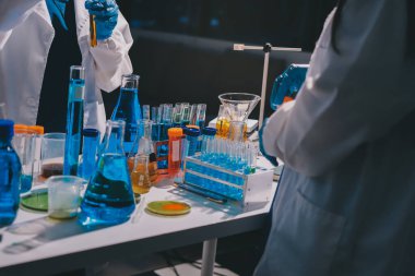 Bilimadamı laboratuarda tıbbi örnekleri mikro plakaya yerleştiriyor.