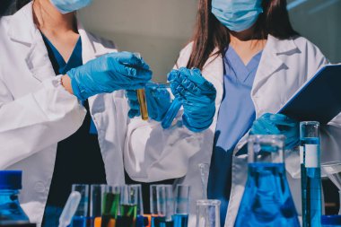 Bilimadamı laboratuarda tıbbi örnekleri mikro plakaya yerleştiriyor.