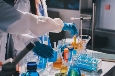 Bilimadamı laboratuarda tıbbi örnekleri mikro plakaya yerleştiriyor.