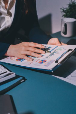 Uzman kadın Asyalı kadınlar idari hesap maliyetli veri numaralarını gözden geçirirler vergi denetleme bürosunda aylık gerçek maliyet varyansı raporu hazırlarlar. ESG tablo bütçe denetimi ERP süreci servis projesi.