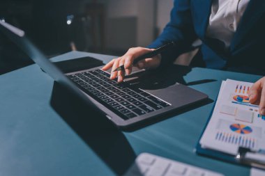 Uzman kadın Asyalı kadınlar idari hesap maliyetli veri numaralarını gözden geçirirler vergi denetleme bürosunda aylık gerçek maliyet varyansı raporu hazırlarlar. ESG tablo bütçe denetimi ERP süreci servis projesi.