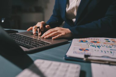 Uzman kadın Asyalı kadınlar idari hesap maliyetli veri numaralarını gözden geçirirler vergi denetleme bürosunda aylık gerçek maliyet varyansı raporu hazırlarlar. ESG tablo bütçe denetimi ERP süreci servis projesi.