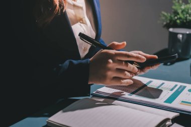 Uzman kadın Asyalı kadınlar idari hesap maliyetli veri numaralarını gözden geçirirler vergi denetleme bürosunda aylık gerçek maliyet varyansı raporu hazırlarlar. ESG tablo bütçe denetimi ERP süreci servis projesi.