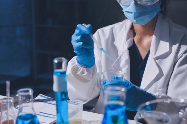 Bilimadamı laboratuarda tıbbi örnekleri mikro plakaya yerleştiriyor.