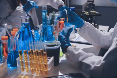 Bilimadamı laboratuarda tıbbi örnekleri mikro plakaya yerleştiriyor.