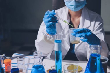 Bilimadamı laboratuarda tıbbi örnekleri mikro plakaya yerleştiriyor.