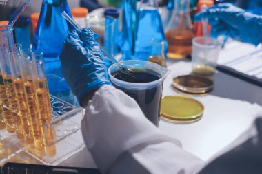 Bilimadamı laboratuarda tıbbi örnekleri mikro plakaya yerleştiriyor.