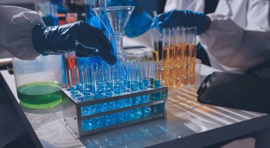 Bilimadamı laboratuarda tıbbi örnekleri mikro plakaya yerleştiriyor.