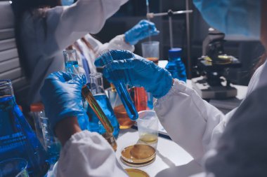 Bilimadamı laboratuarda tıbbi örnekleri mikro plakaya yerleştiriyor.