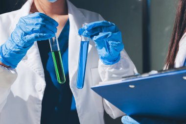 Bilimadamı laboratuarda tıbbi örnekleri mikro plakaya yerleştiriyor.