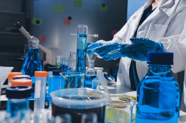 Bilimadamı laboratuarda tıbbi örnekleri mikro plakaya yerleştiriyor.