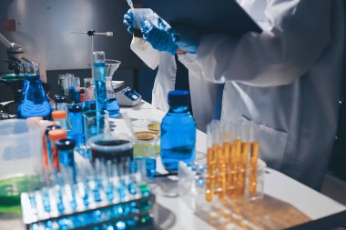 Bilimadamı laboratuarda tıbbi örnekleri mikro plakaya yerleştiriyor.