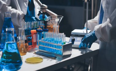 Bilimadamı laboratuarda tıbbi örnekleri mikro plakaya yerleştiriyor.