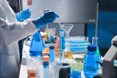 Bilimadamı laboratuarda tıbbi örnekleri mikro plakaya yerleştiriyor.