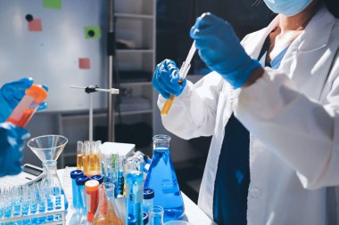 Bilimadamı laboratuarda tıbbi örnekleri mikro plakaya yerleştiriyor.