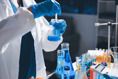 Bilimadamı laboratuarda tıbbi örnekleri mikro plakaya yerleştiriyor.