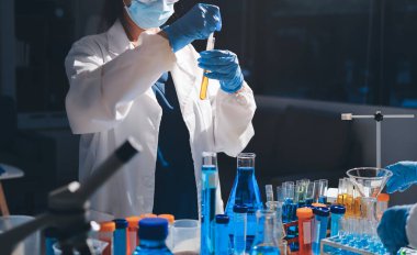 Bilimadamı laboratuarda tıbbi örnekleri mikro plakaya yerleştiriyor.