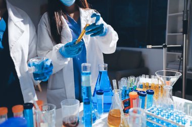 Bilimadamı laboratuarda tıbbi örnekleri mikro plakaya yerleştiriyor.