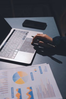 Uzman kadın Asyalı kadınlar idari hesap maliyetli veri numaralarını gözden geçirirler vergi denetleme bürosunda aylık gerçek maliyet varyansı raporu hazırlarlar. ESG tablo bütçe denetimi ERP süreci servis projesi.