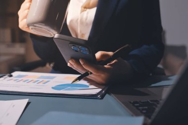 Uzman kadın Asyalı kadınlar idari hesap maliyetli veri numaralarını gözden geçirirler vergi denetleme bürosunda aylık gerçek maliyet varyansı raporu hazırlarlar. ESG tablo bütçe denetimi ERP süreci servis projesi.