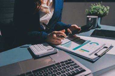Uzman kadın Asyalı kadınlar idari hesap maliyetli veri numaralarını gözden geçirirler vergi denetleme bürosunda aylık gerçek maliyet varyansı raporu hazırlarlar. ESG tablo bütçe denetimi ERP süreci servis projesi.
