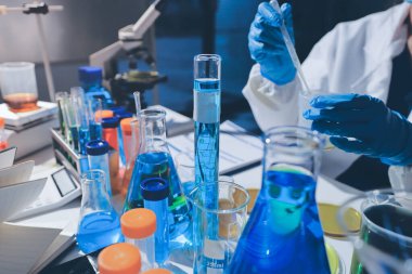 Bilimadamı laboratuarda tıbbi örnekleri mikro plakaya yerleştiriyor.