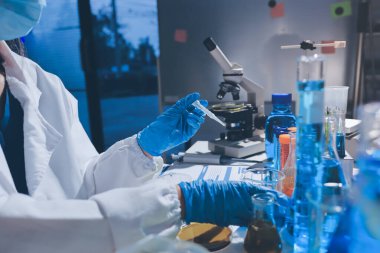 Bilimadamı laboratuarda tıbbi örnekleri mikro plakaya yerleştiriyor.