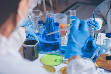 Bilimadamı laboratuarda tıbbi örnekleri mikro plakaya yerleştiriyor.