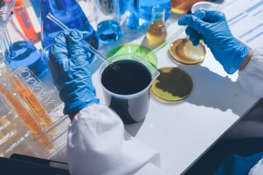 Bilimadamı laboratuarda tıbbi örnekleri mikro plakaya yerleştiriyor.