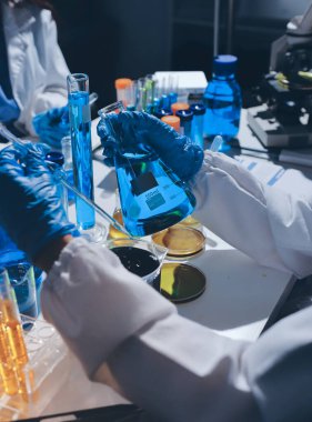 Bilimadamı laboratuarda tıbbi örnekleri mikro plakaya yerleştiriyor.