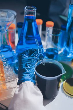 Bilimadamı laboratuarda tıbbi örnekleri mikro plakaya yerleştiriyor.