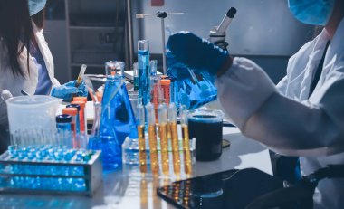 Bilimadamı laboratuarda tıbbi örnekleri mikro plakaya yerleştiriyor.