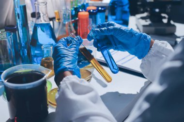 Bilimadamı laboratuarda tıbbi örnekleri mikro plakaya yerleştiriyor.