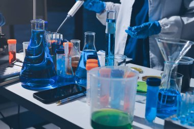 Bilimadamı laboratuarda tıbbi örnekleri mikro plakaya yerleştiriyor.