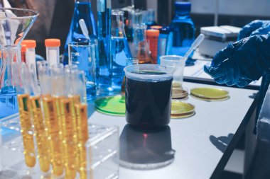 Bilimadamı laboratuarda tıbbi örnekleri mikro plakaya yerleştiriyor.