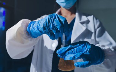 Bilimadamı laboratuarda tıbbi örnekleri mikro plakaya yerleştiriyor.