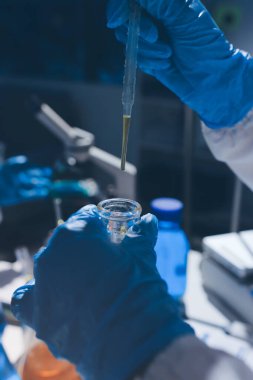 Bilimadamı laboratuarda tıbbi örnekleri mikro plakaya yerleştiriyor.