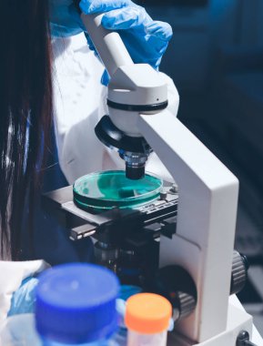 Bilimadamı laboratuarda tıbbi örnekleri mikro plakaya yerleştiriyor.