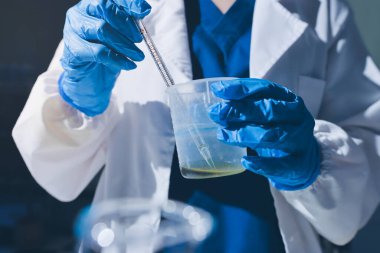 Bilimadamı laboratuarda tıbbi örnekleri mikro plakaya yerleştiriyor.