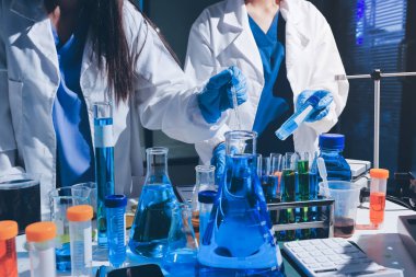 Bilimadamı laboratuarda tıbbi örnekleri mikro plakaya yerleştiriyor.