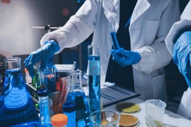 Bilimadamı laboratuarda tıbbi örnekleri mikro plakaya yerleştiriyor.