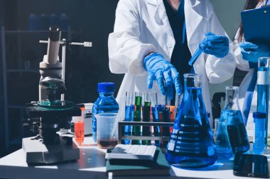 Bilimadamı laboratuarda tıbbi örnekleri mikro plakaya yerleştiriyor.