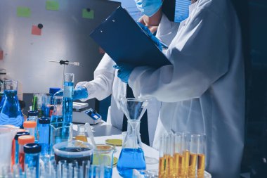 Bilimadamı laboratuarda tıbbi örnekleri mikro plakaya yerleştiriyor.