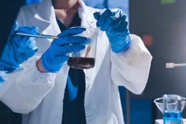 Bilimadamı laboratuarda tıbbi örnekleri mikro plakaya yerleştiriyor.